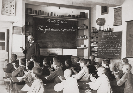 Une classe de garçons en 1900. Chaque élève apprend à tenir son porte-plume avec 3 doigts. (© Musée national de l'éducation - CNDP)