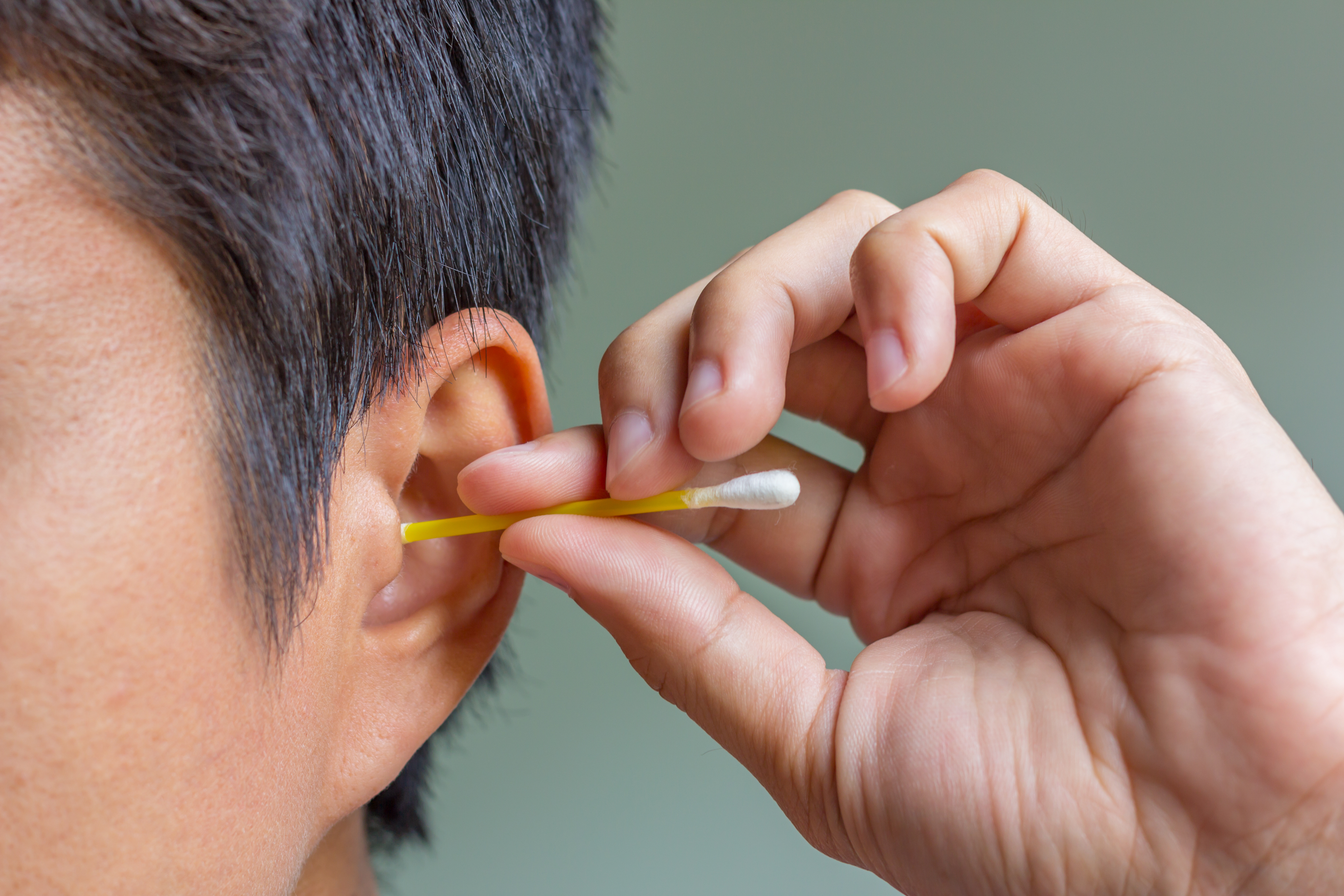 male cleaning ear with cotton bud © Fosupaksorn /Adobe Stock